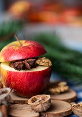 Baked apples with cinnamon on rustic background. Autumn or winter dessert. Closeup photo of a tasty baked apples with christmas decoration