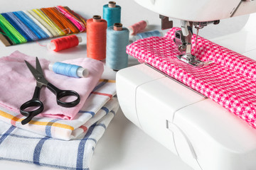 Multicolored sewing thread, sewing machine, scissors, buttons and various accessories for a tailor...