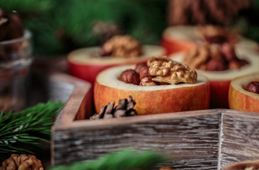 Baked apples with cinnamon on rustic background. Autumn or winter dessert. Closeup photo of a tasty baked apples with christmas decoration