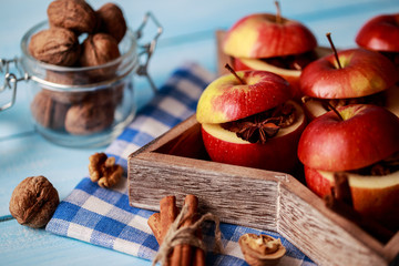 Baked apples with cinnamon on rustic background. Autumn or winter dessert. Closeup photo of a tasty baked apples with christmas decoration