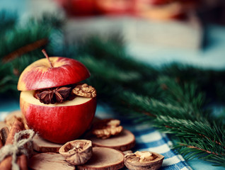 Baked apples with cinnamon on rustic background. Autumn or winter dessert. Closeup photo of a tasty baked apples with christmas decoration