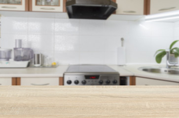 Wooden textured table over blurred kitchen interior background