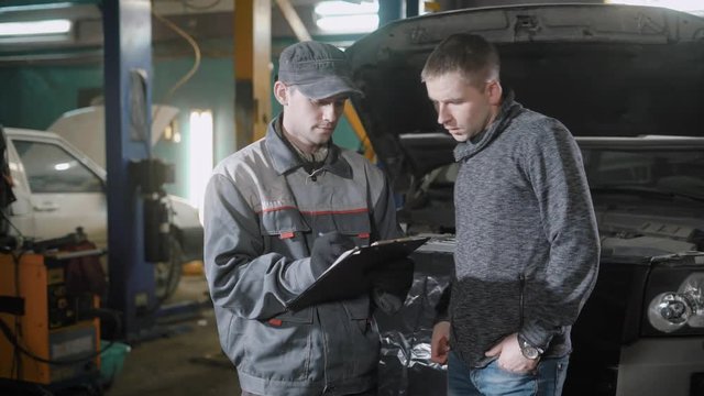 Mechanic and a man discussing the cost of car service.