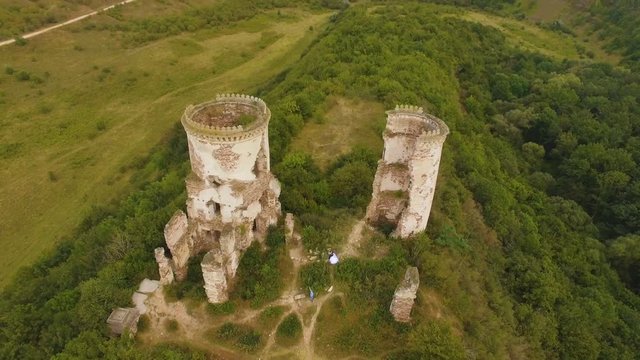 Couple walking through the ruins of the fortress towers. Aerial shooting 4k