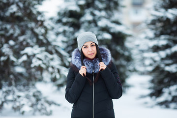 Winter portrait of young beautiful brunette woman wearing warm clothes. Snowing winter beauty fashion concept