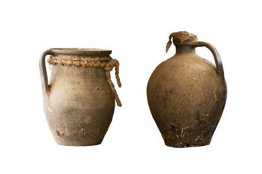 two old ceramic dishes for water and oil made from dark clay - isolated
