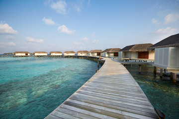 Fototapeta na wymiar Water bungalows in hotel on Maldives. Villas on Indian ocean at luxury spa resort.