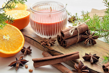 oranges with anisestars, cinnamon sticks, juniper branch and candle