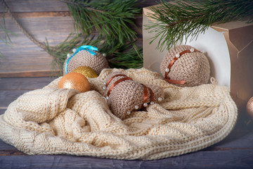 Knitted Christmas decorations lie on a blanket in a wooden decorations