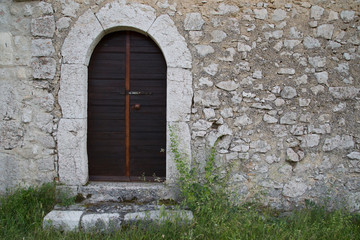 Fototapeta na wymiar Ingresso di una casa di pietra antica 