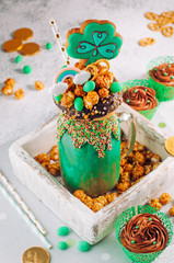 Green freak shake topping with clover cookie in wooden box filled with popcorn