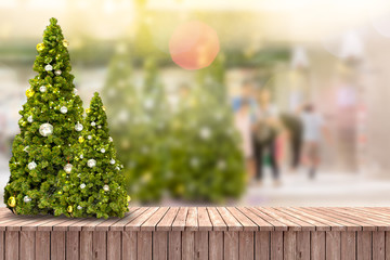 Christmas trees on wooden floor and blurred background.