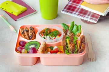 Poster Open lunch box with healthy lunch on office table near backpack and mug © lithiumphoto