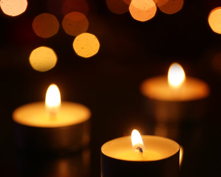 Three candles with bokeh spots
