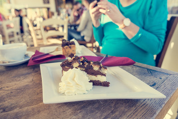 Pregnant woman taking a snapshot of delicious cake.
