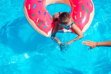 Girl on inflatable ring in swimming pool