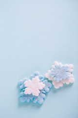 Two Christmas sprinkles in form of winter snowflakes on light blue background