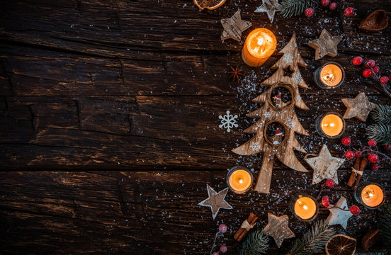 Christmas background with wooden decorations and candles. Free space for text.