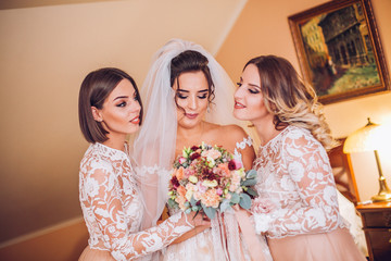 Beautiful bride & bridesmaids posing in room before wedding