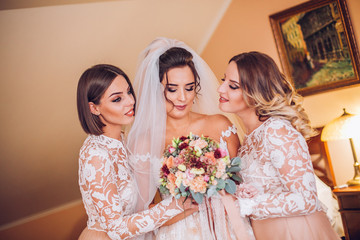 Beautiful bride & bridesmaids posing in room before wedding