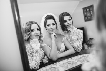 Beautiful bride & bridesmaids posing in room before wedding