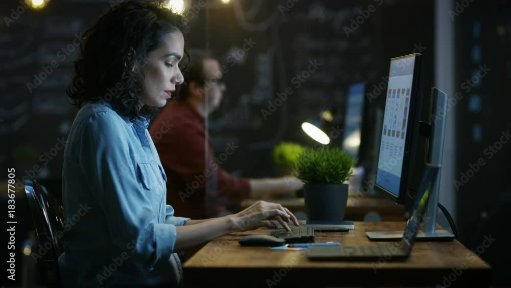 Poster stressed, overworked female mobile phone app designer holds her head in hands while working on a per