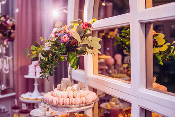 Delicious sweets and fruits on candy buffet. Lot of colorful desserts on table. Chocolate fountain. Party catering.