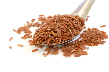 brown rice in spoon on white background