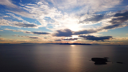 Aerial drone bird's eye view of sunset in famous coast of Voula with beautiful scattered clouds, Athens riviera, Attica, Greece