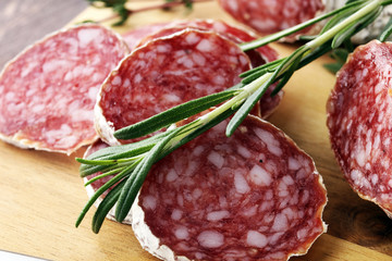 Marble cutting board with sliced salami on it