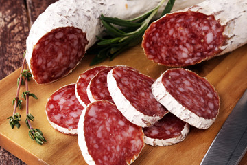 Marble cutting board with sliced salami on it