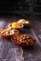 Salty snacks. Pretzels, chips, crackers in wooden bowls