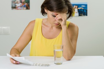  Mature woman with pills and glass of water at home - age, medic