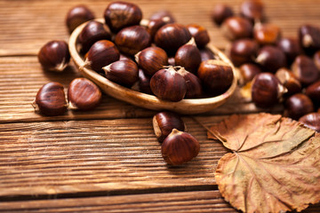 Ripe chestnuts in a frying pan on old wooden table close up with copy space. Roasted Chestnuts for Christmas'n