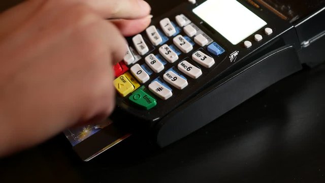 Hand dialing pin code on pin pad of pos terminal.