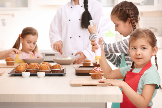 Group of children and teacher in kitchen during cooking classes