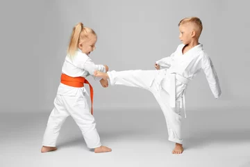 Photo sur Plexiglas Arts martiaux Petits enfants pratiquant le karaté sur fond clair