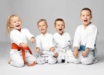 Photo sur Aluminium Arts martiaux Petits enfants en karategi sur fond clair