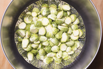 Brussel Sprouts in a steaming rack inside of a pot for cooking