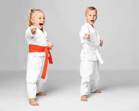 Little children practicing karate on light background
