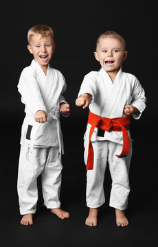 Little children practicing karate on dark background