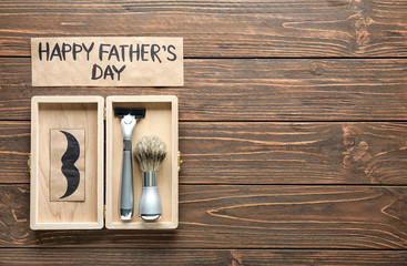 Happy Father's Day concept. Shaving accessories in gift box on wooden background
