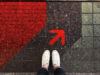 Red arrow on street and sneaker shoe background