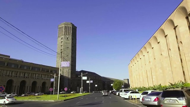 Car driving wide city street, passing Yerevan Brandy-Wine Factory in Armenia