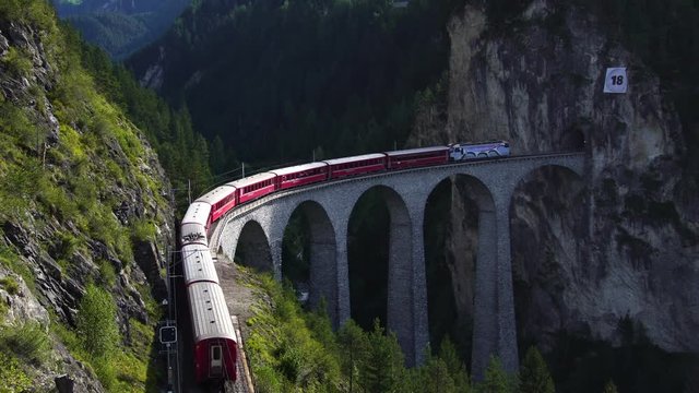 Swiss red train on Landwasser viaduct bridge on bernina pass glacier express in Switzerland