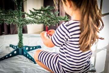 Little girl decorating christmas tree