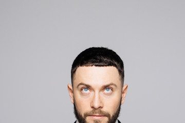 Obraz premium Cropped close up portrait of face charming man in a business suit looking up on white background
