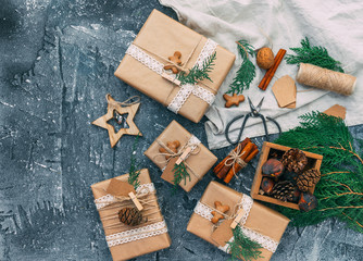 Homemade wrapped rustic brown paper packages with various natural things on blue vintage background. Flat lay, top view