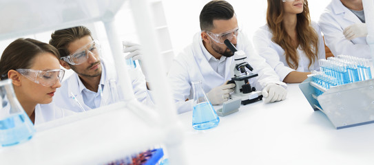 background image is a group of scientists working in the laboratory.