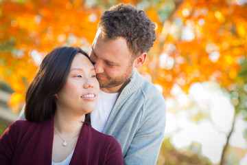 Fototapeta premium Outdoor Fall Portrait of Chinese and Caucasian Young Adult Couple.